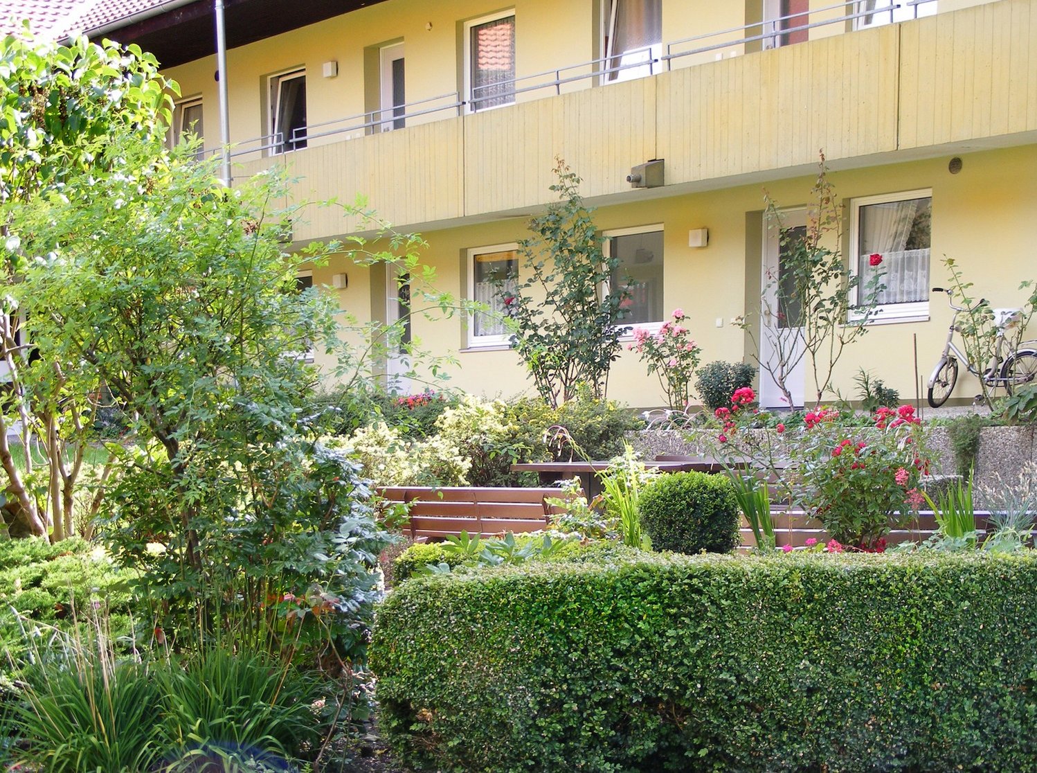 Ansicht von Gartenseite, Mehrfamilienhaus, gelbe Fassade in Lehrte