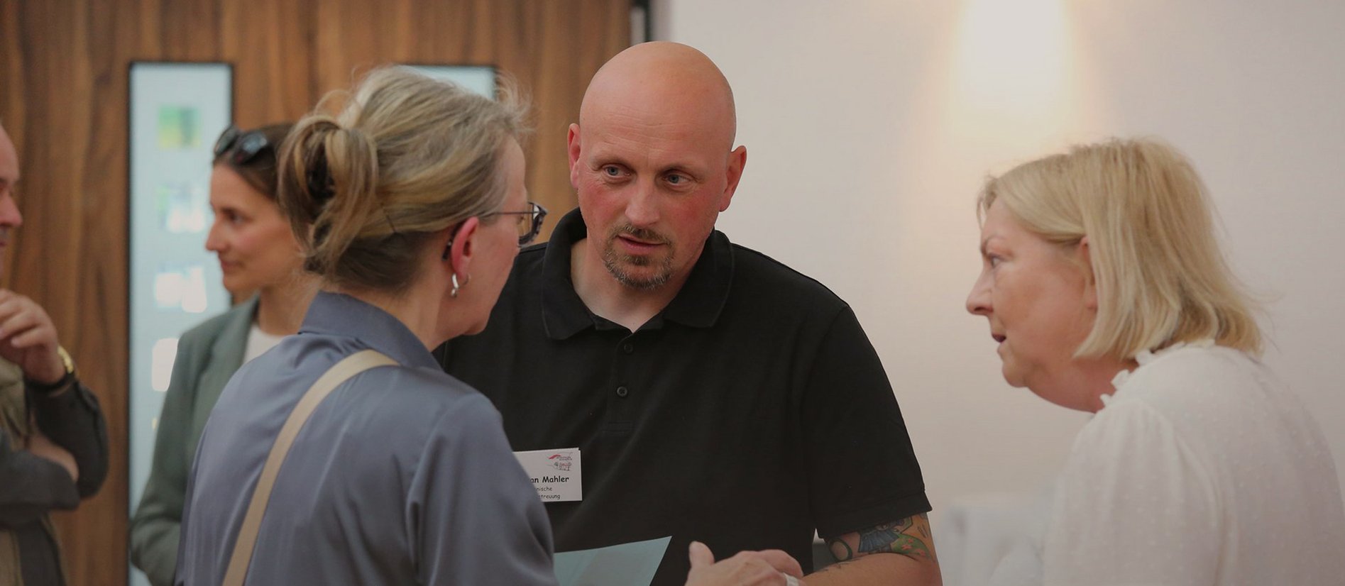 Heimatwerk-Mitarbeiter hört Mieterin aufmerksam zu