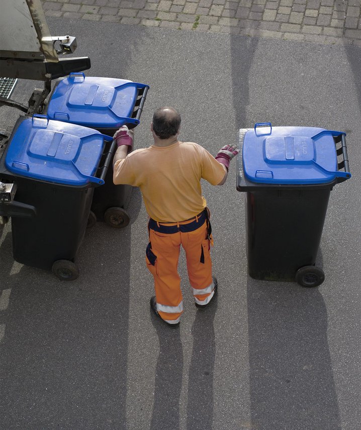 Müllwerker mit drei Mülltonnen von oben fotografiert
