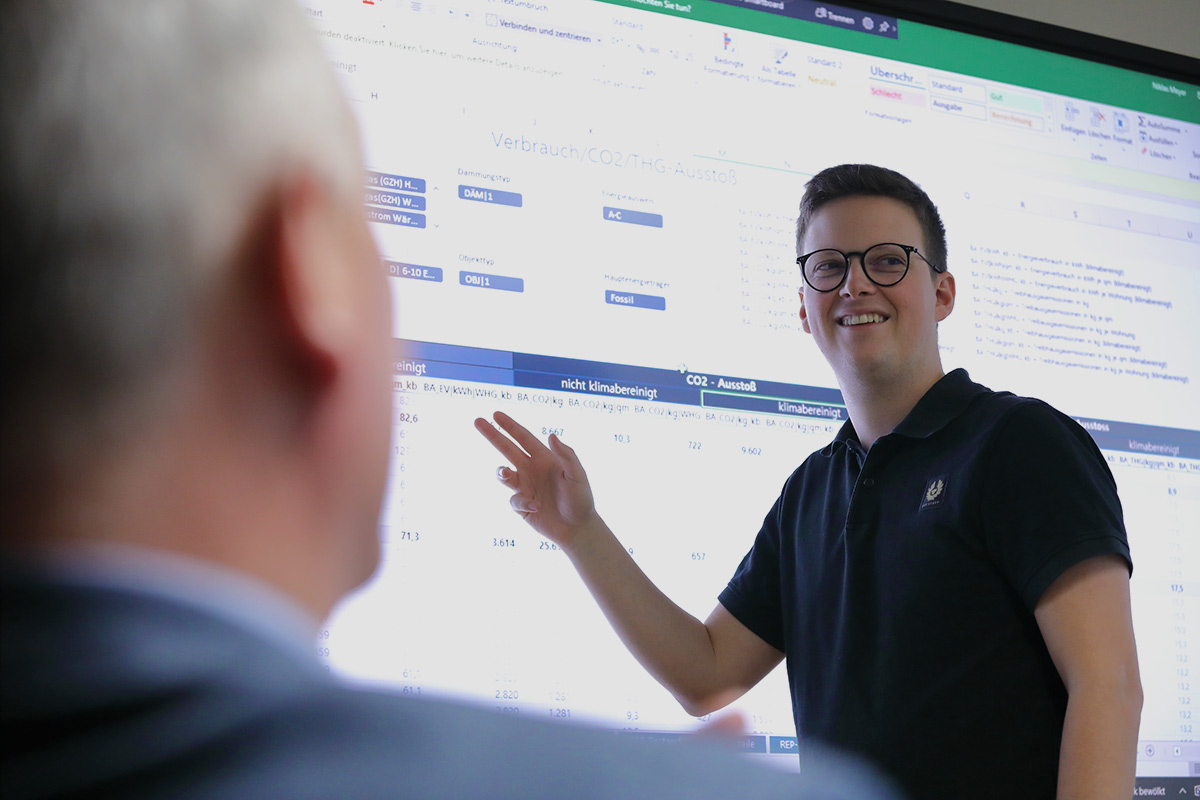 Nachhaltigkeitsmanager Niklas Meyer präsentiert am großen Bildschirm