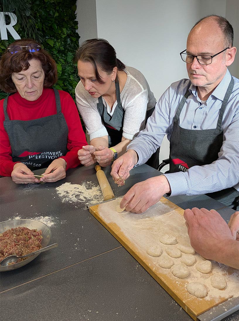 Larissa Holtheuer zeigt Jutta Schütte und Henning Scholz die Falttechnik